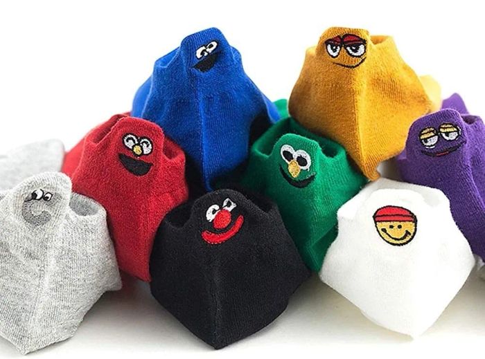 A collection of socks, each displaying different amusing character faces on the back tabs, making them a fun addition to any outfit.