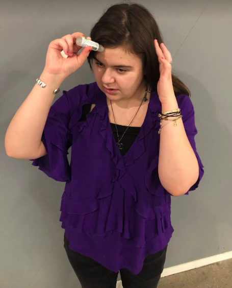 person applying the roller to their forehead