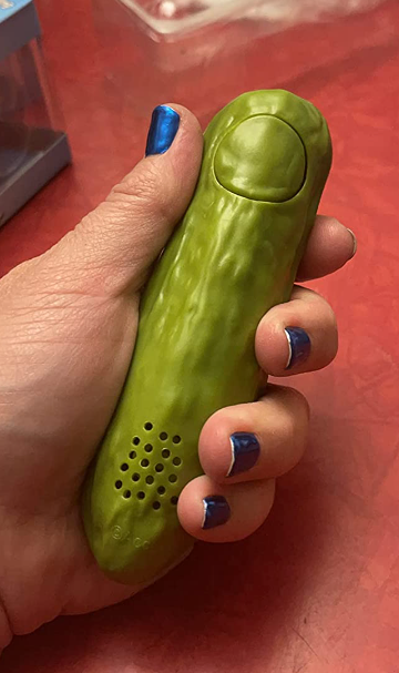 A reviewer holding the yodeling pickle