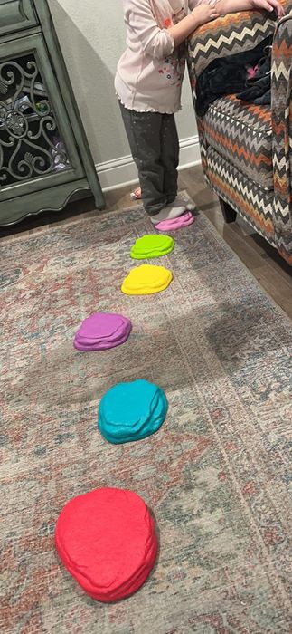 A child jumping on colorful stepping stones in a cozy living room