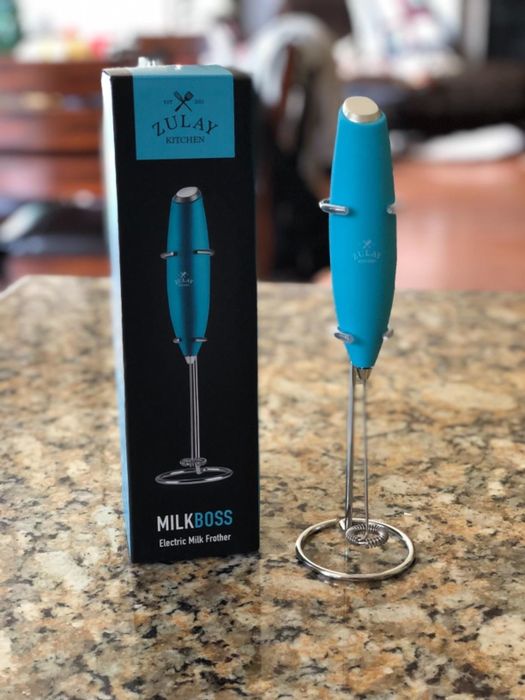 Reviewer showcasing the frother on a kitchen table, ready for use.