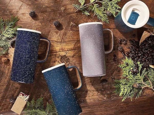 three tall mugs made from speckled ceramic, featuring lids and handles