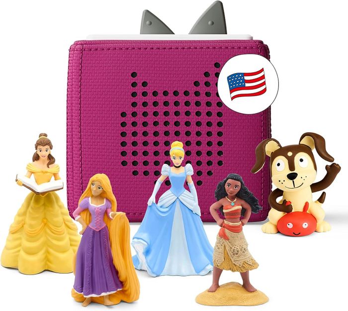 A children's audio player accompanied by figurines of Belle, Rapunzel, Cinderella, Moana, and a dog positioned next to the player, with an American flag icon displayed.
