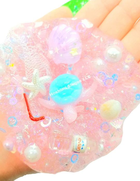 hand holding slime filled with charms