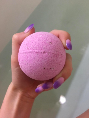 a reviewer holding a large bath bomb in their hands