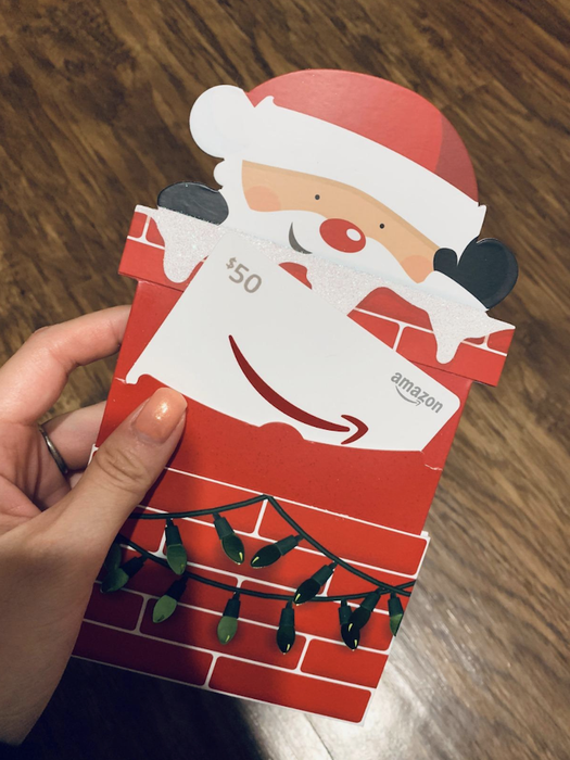A reviewer’s picture of a Santa Claus-shaped gift card popping out of a chimney