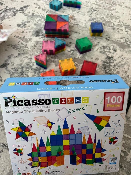 A Picasso Tiles box with magnetic building pieces scattered around, offering limitless opportunities for creativity and imaginative play