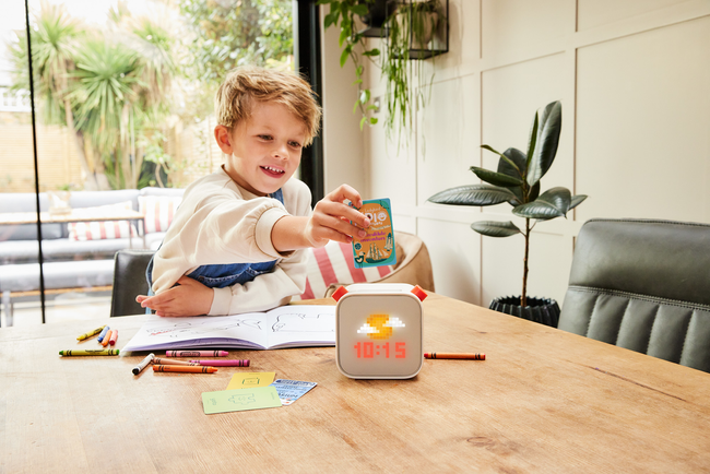 A child is having fun playing with a Yoto player, engaging with its interactive features.