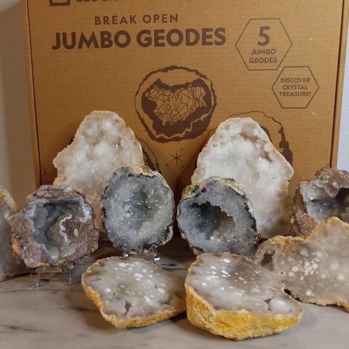 Geode kit box with several geodes cracked open, revealing stunning crystal interiors. Perfect for those keen on discovering hidden crystal treasures.