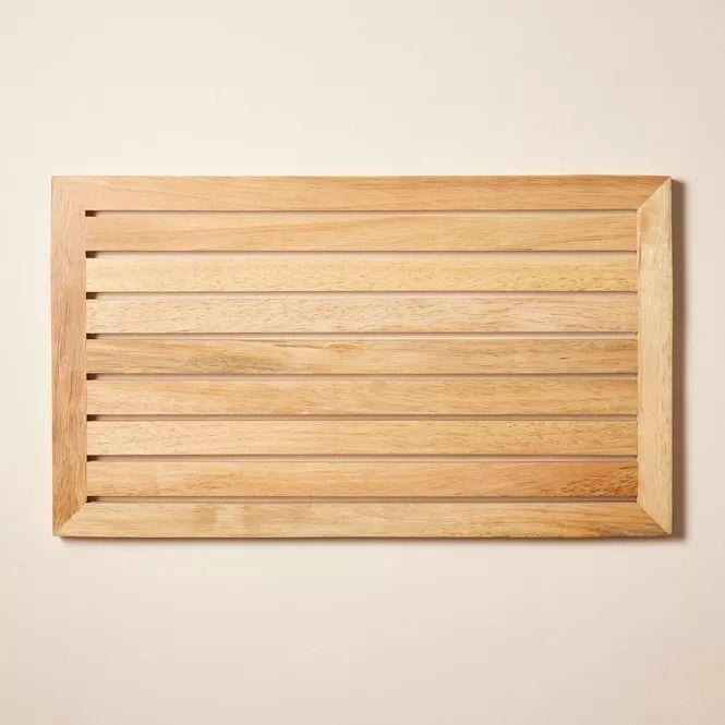 A bath mat with a wooden slatted design, ideal for introducing a natural, stylish touch to your bathroom decor.