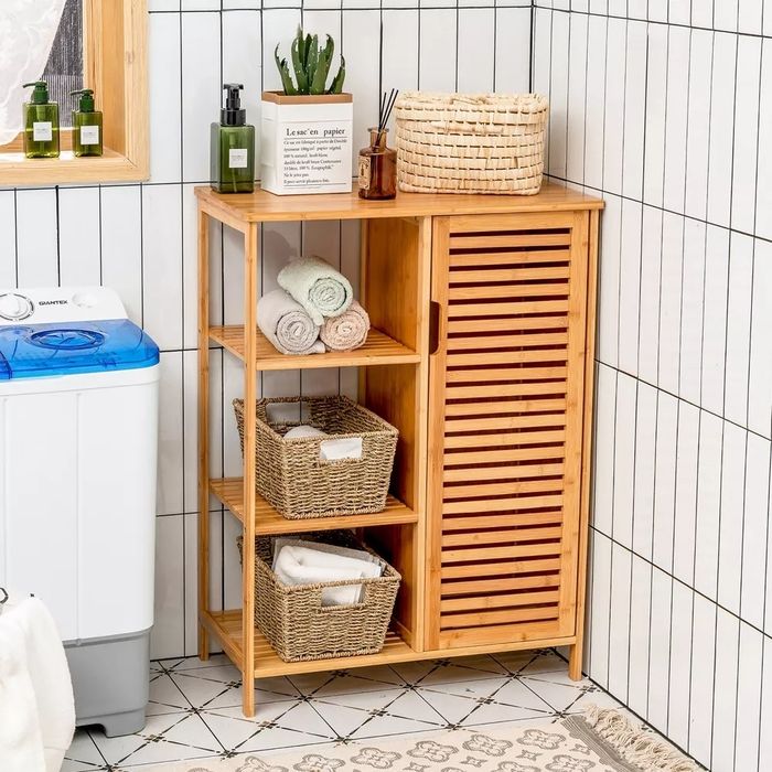 The bamboo storage cabinet placed in the corner of a bathroom.