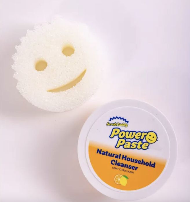A Scrub Daddy and a jar of PowerPaste placed on a countertop, ready to clean.
