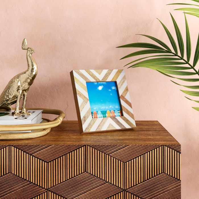 A square frame in shades of brown and white, featuring a scenic beach photo within.