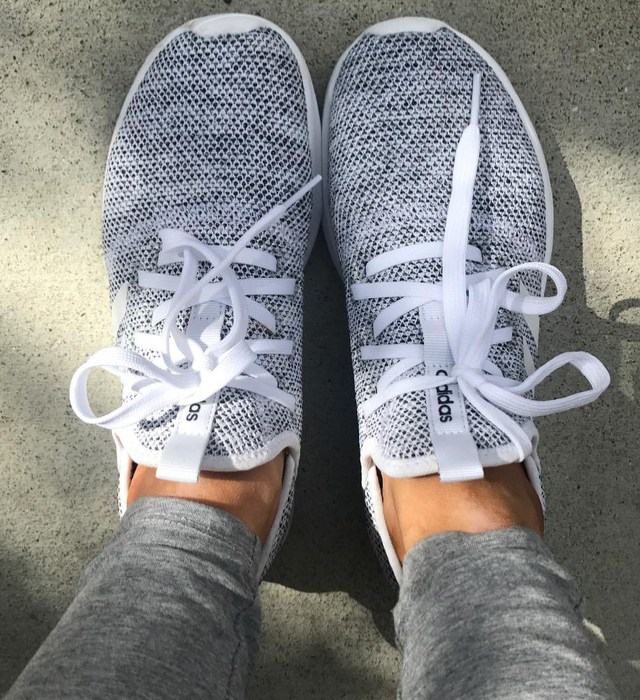 A reviewer sporting the gray sneakers