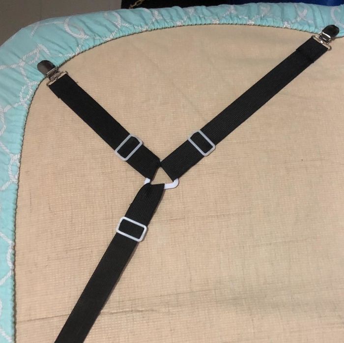 A review image featuring three-sided sheet clips holding a fitted sheet securely beneath a mattress.