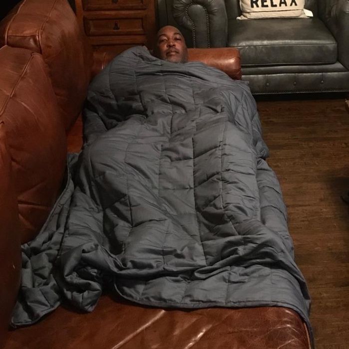 Image of reviewer laying under gray blanket