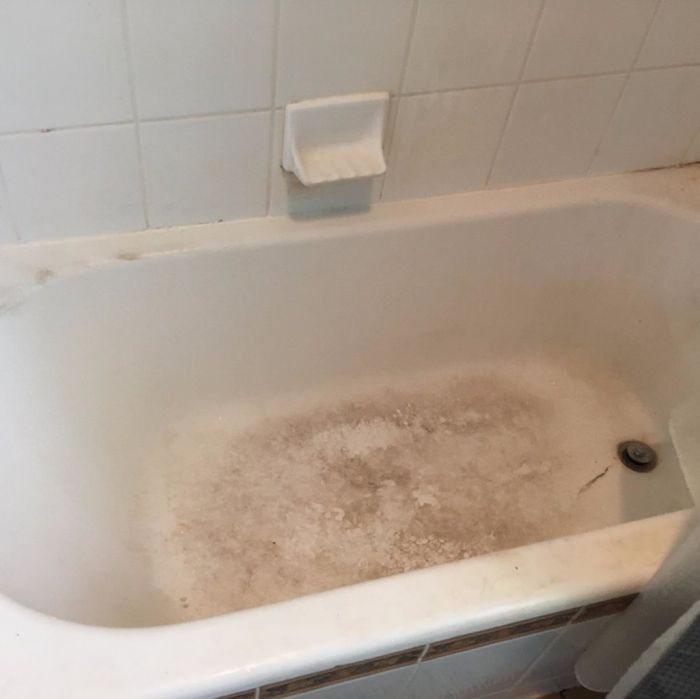 A reviewer's 'before' photo showcasing a bathtub covered in stains.