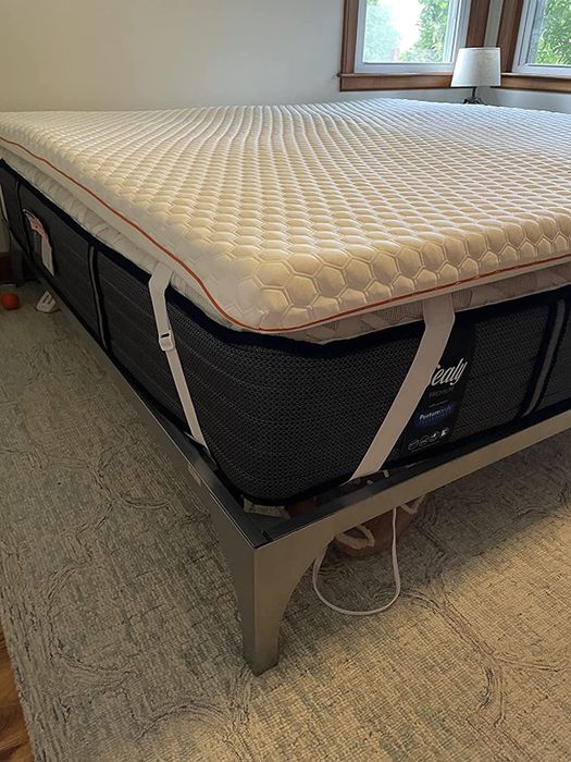 Side view of the same reviewer’s mattress with the topper, highlighting the straps