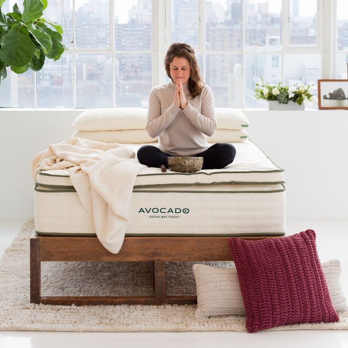 A woman resting on an Avocado green mattress topper