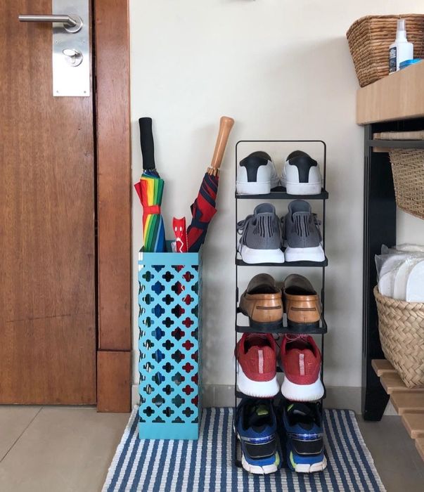 A photo showing a shoe tower packed with shoes, placed in a cozy entryway.