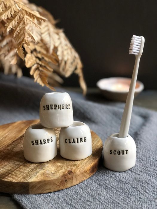 Four toothbrush holders, each labeled with individual names.