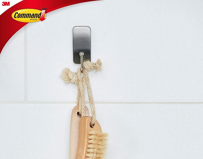 A shower brush hanging on one of the hooks