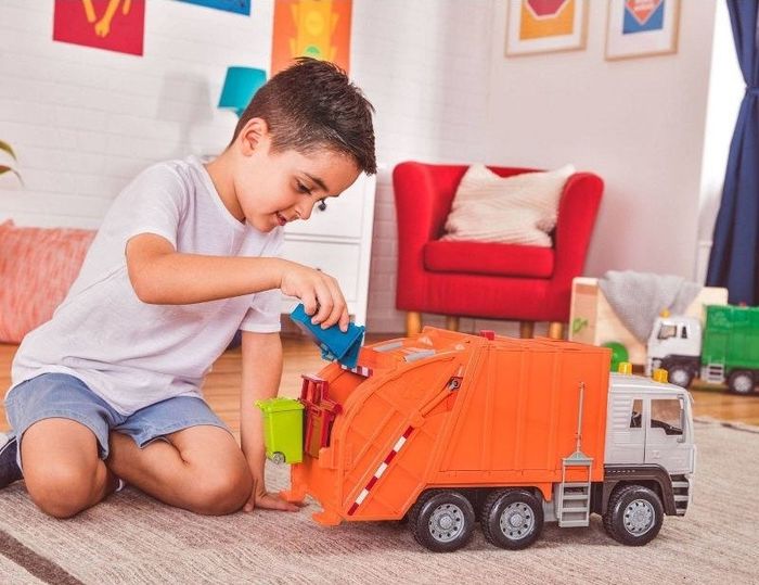 A child playing with a garbage truck