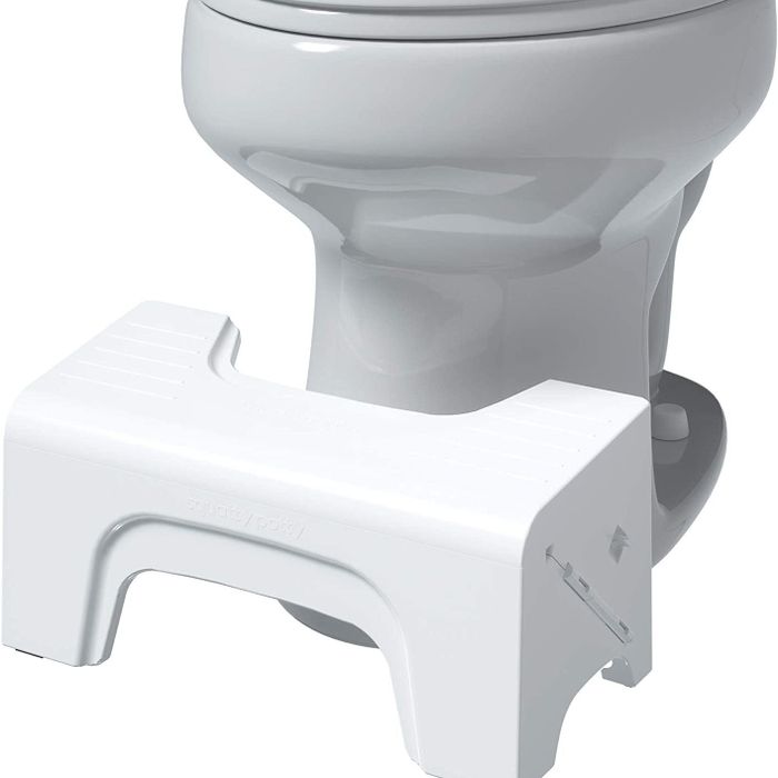 A compact stool placed in front of the toilet
