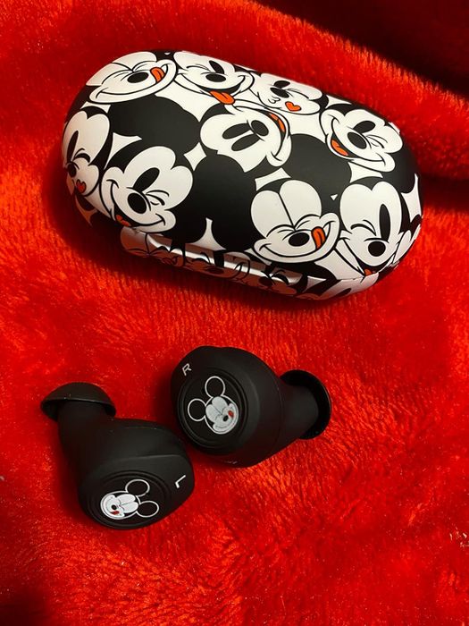 a sleek black and white earbud case adorned with a subtle Mickey Mouse print