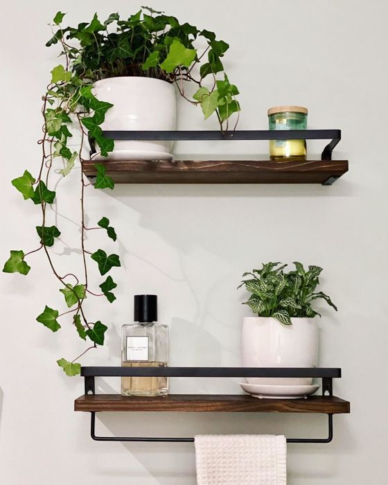 Reviewer photo of the shelves holding plants, a candle, and a perfume bottle