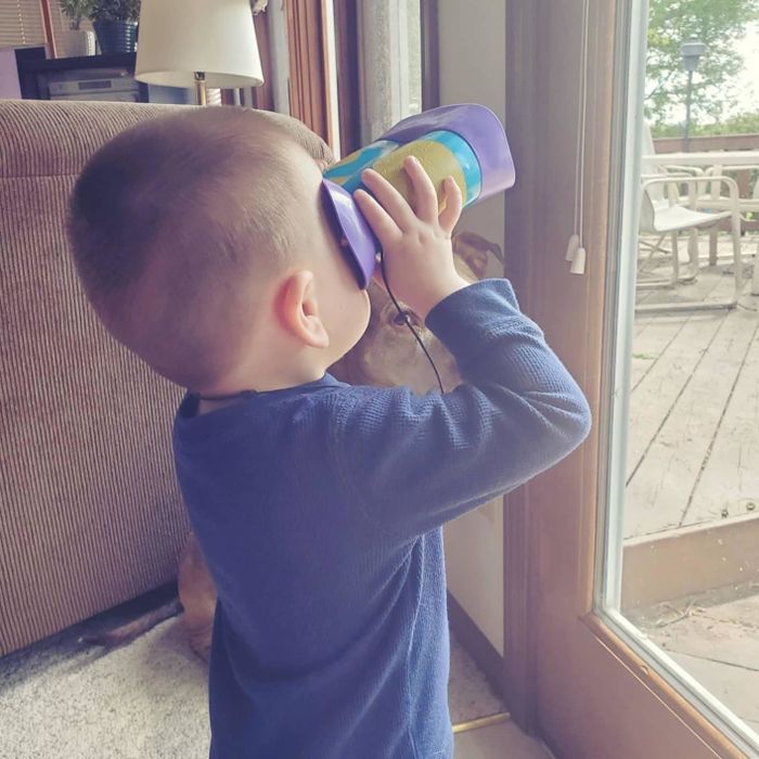 A reviewer's child is seen holding the binoculars, gazing out of the window