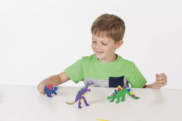 A child playing with clay dinosaurs