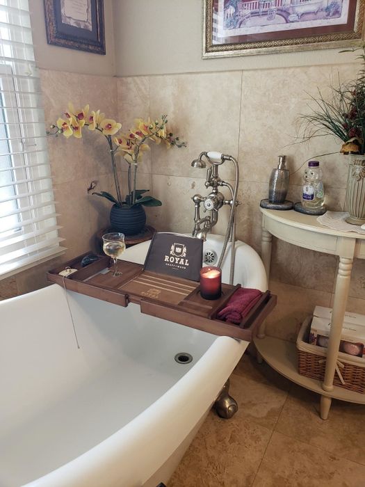 A reviewer's bathtub showcasing a bath tray perfectly positioned on top