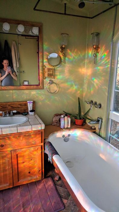 Rainbows scattering across the walls from the shimmering privacy film on a bathroom window