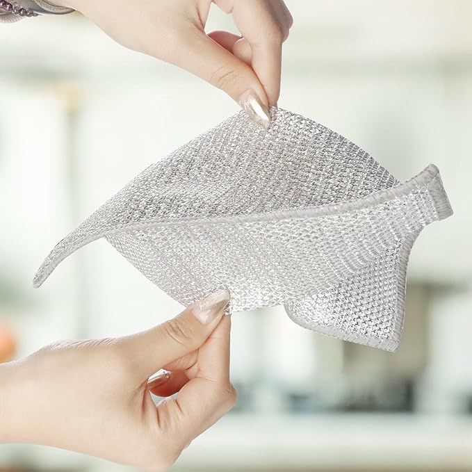 Hands stretch and mold a shiny, flexible metallic mesh fabric.