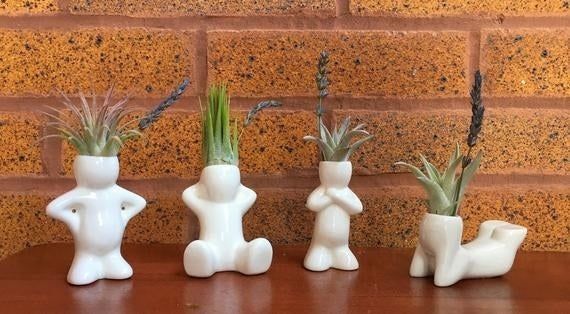 Person-shaped planters in various sitting and standing poses