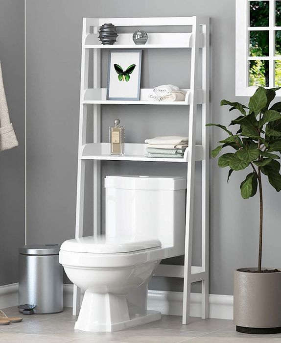 A shelving unit installed over a toilet, neatly holding various bathroom essentials on its shelves