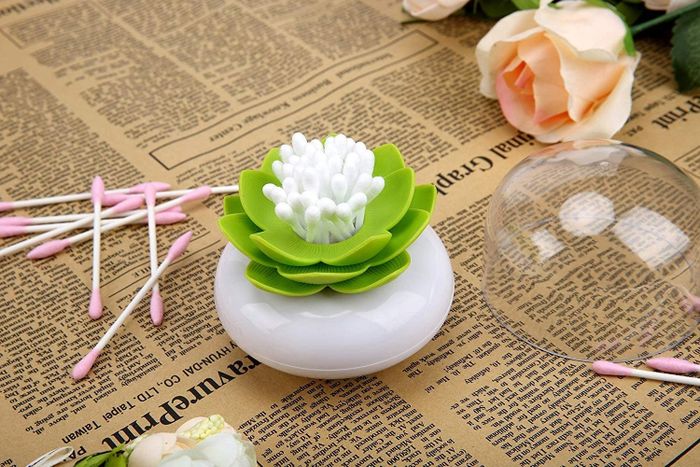 A cotton swab holder shaped like a flower, filled with cotton swabs.