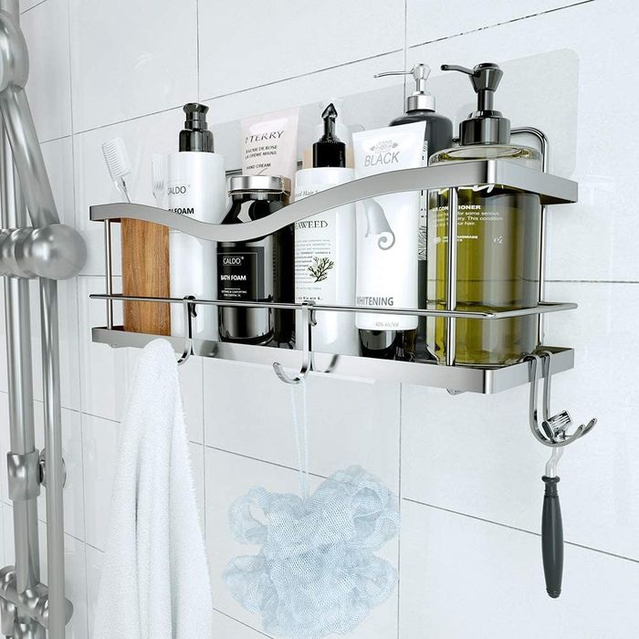 A shower caddy basket hanging in place, filled with various toiletries