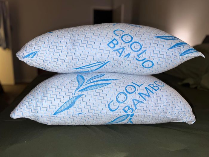 Two bamboo cooling pillows neatly arranged one on top of the other on a bed