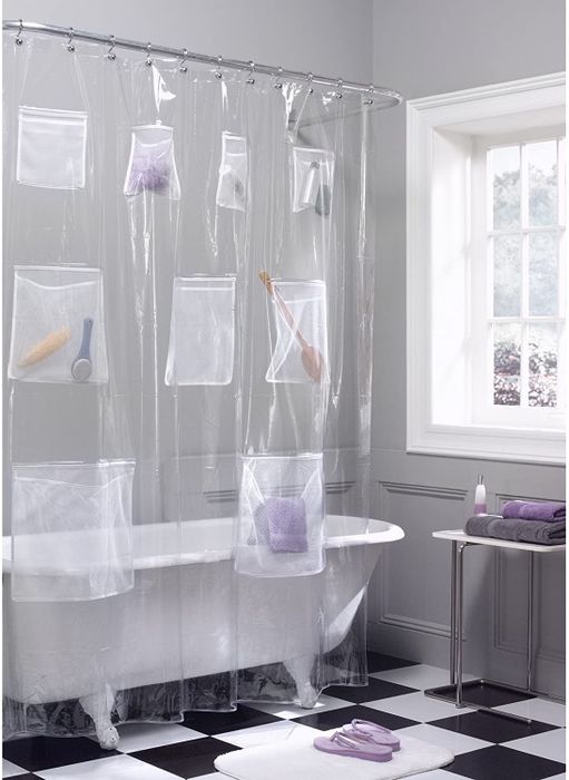 A transparent shower curtain filled with multiple pockets holding bottles and body brushes