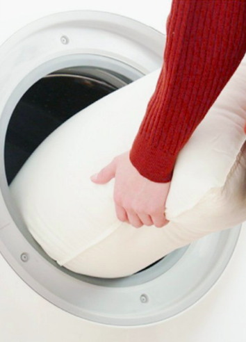 A model placing the pillow into a washing machine
