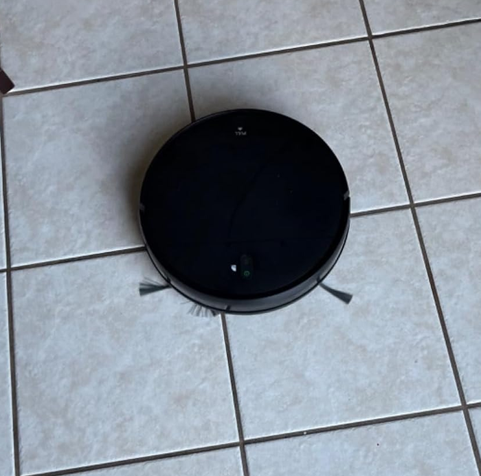 A photo of the sleek black robotic mop that handles the cleaning for you.