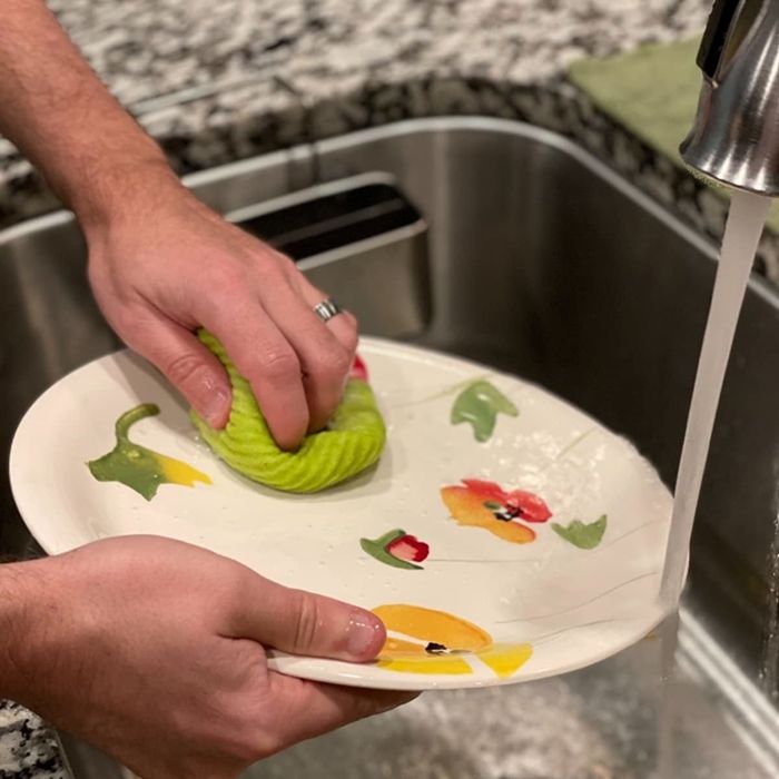 A reviewer using a Swedish dishcloth to wash a plate.
