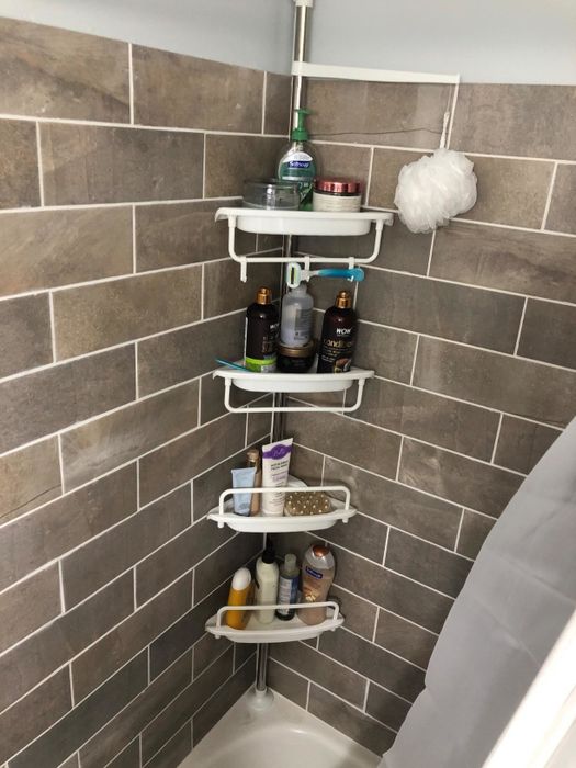 A photo from a reviewer showing a corner shelving unit installed in their shower