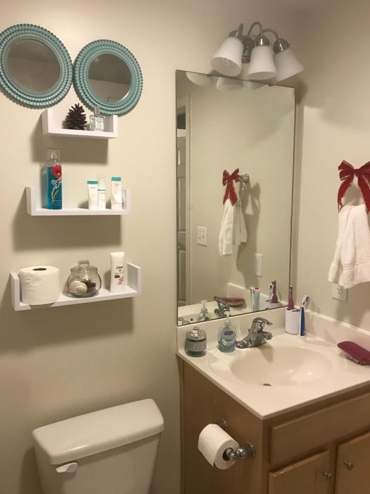 A reviewer's image highlights floating shelves installed on a bathroom wall.