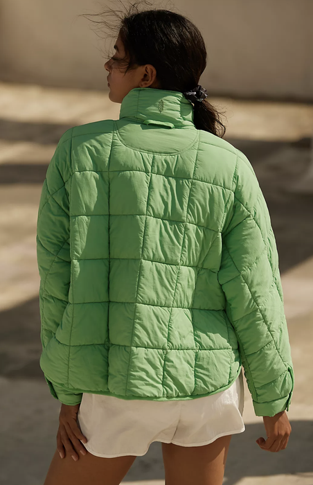 A model demonstrating the back of the puffer jacket in a refreshing green color.