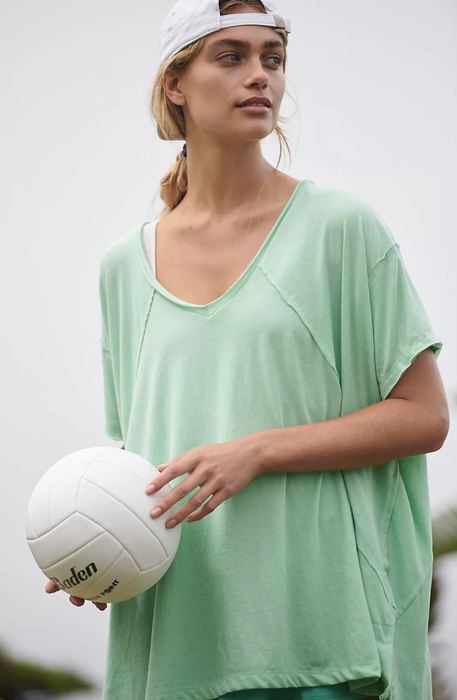 A photo of the model wearing the t-shirt in teal.