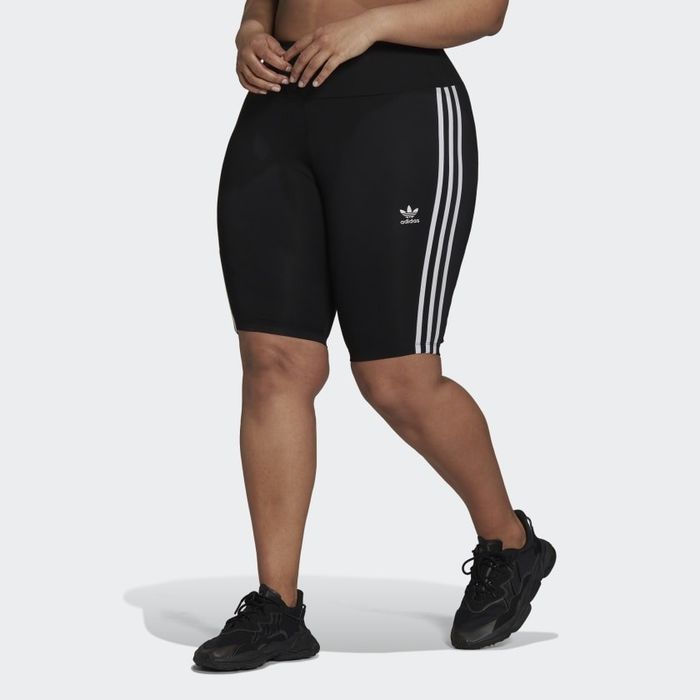 a model sporting the shorts in black with three white stripes on the sides
