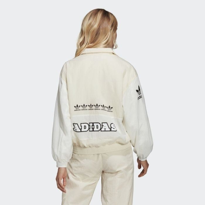 The back view of a model wearing a cream-colored jacket, featuring a graphic print design.